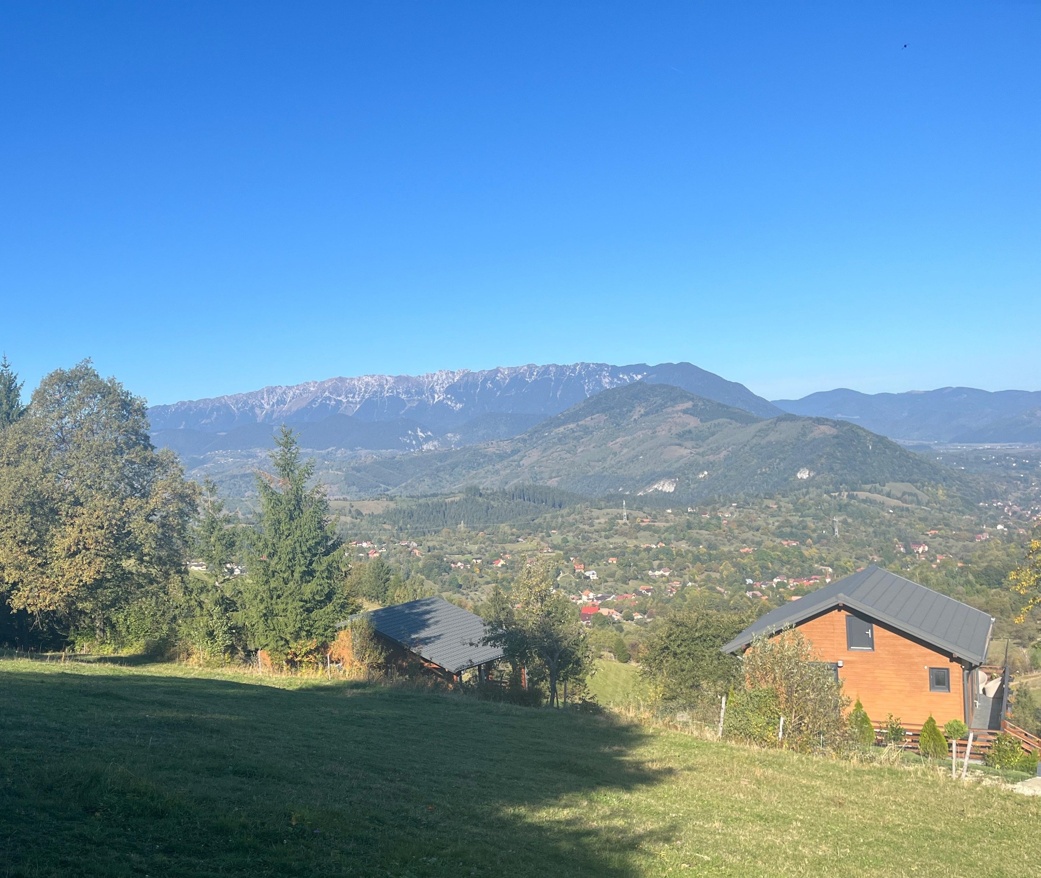 Vedere de pe teren către creasta munților și vale